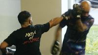 Two individuals practicing martial arts in a room with a window.