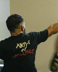 Two individuals practicing martial arts in a room with a window.